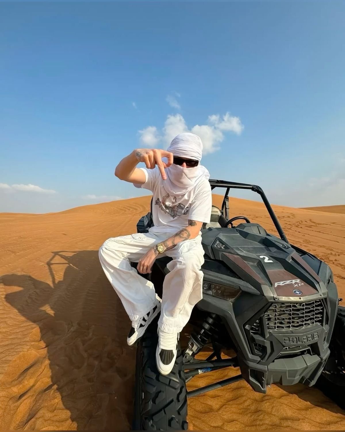 Guest posing on the Polaris RZR dune buggy in the Al Khatim dunes