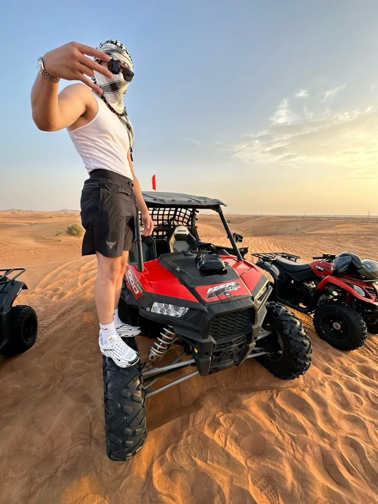 Guest standing on the red Polaris RZR wheel with quad bikes lined up behind