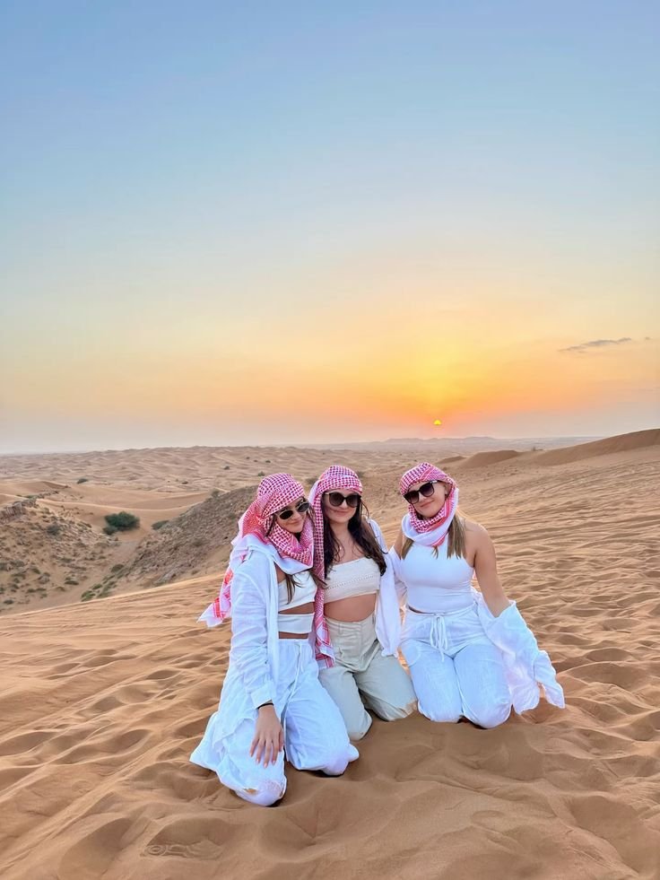 Friends in traditional headscarves at sunset on the dunes – quad bike tour