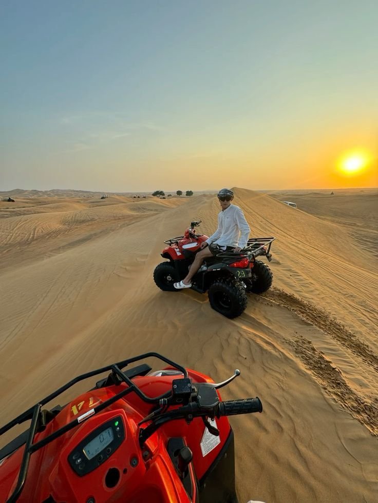 Quad bike convoy riding a dune ridge into the sunset – Abu Dhabi desert safari
