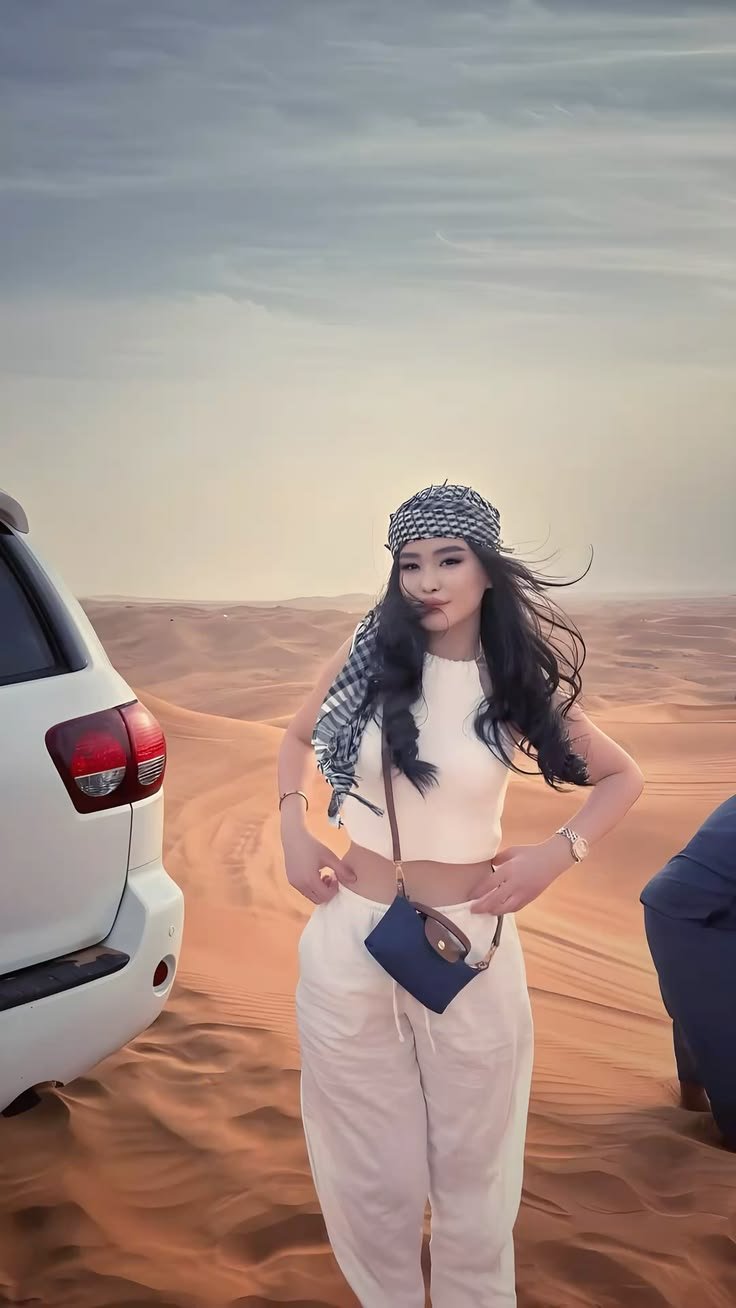 Guest in a keffiyeh beside the safari 4x4 at golden hour