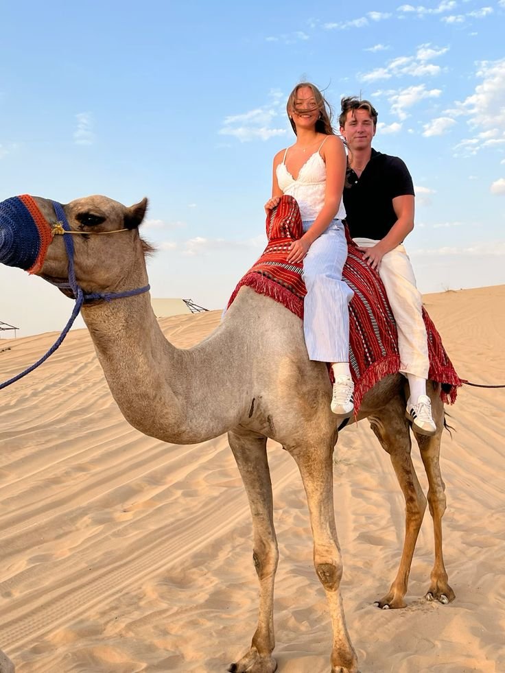 Couple on a camel ride in soft morning light – morning desert safari Abu Dhabi