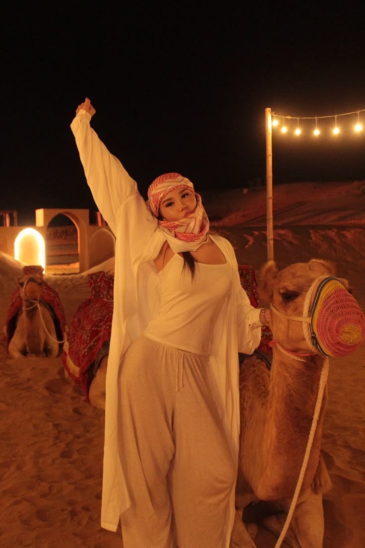 Guest with a camel at the Al Khatim night camp under string lights