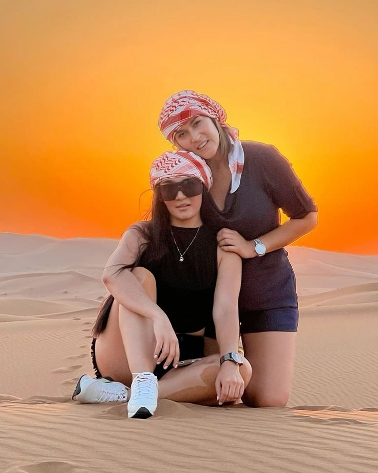 Two friends on the Al Khatim dunes at sunset – private desert safari